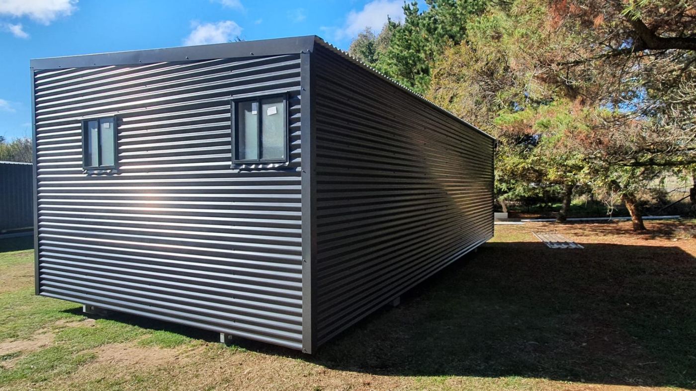 Long-format cabin · charcoal corrugated shell